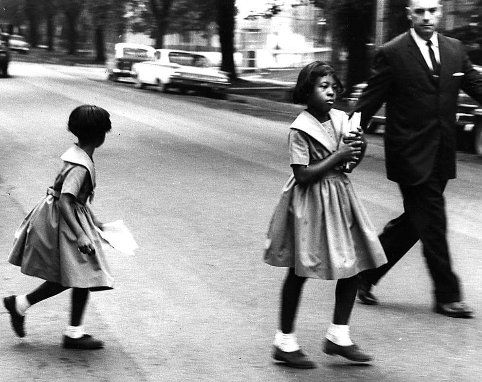 Stoic faced Nadine and Cassandra Wilkinson are shown walking with their principal across a street