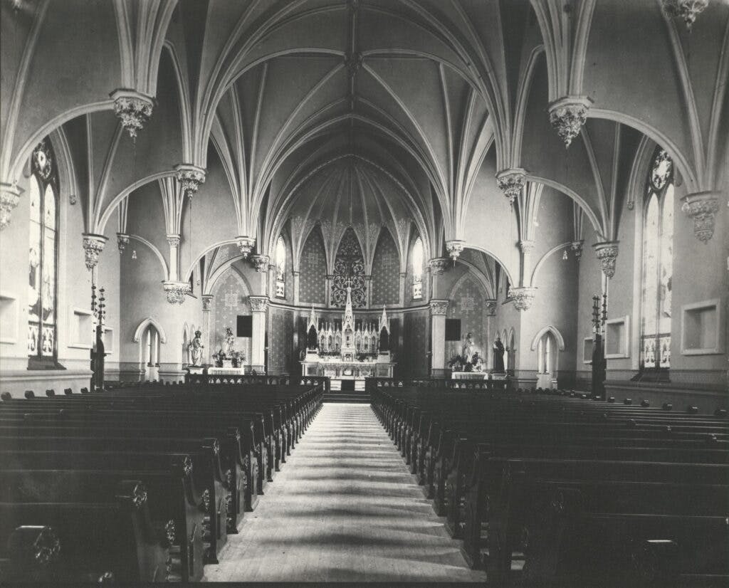 Black and white photo of The beautiful interior of the church with its high vaulted ceilings and large pews