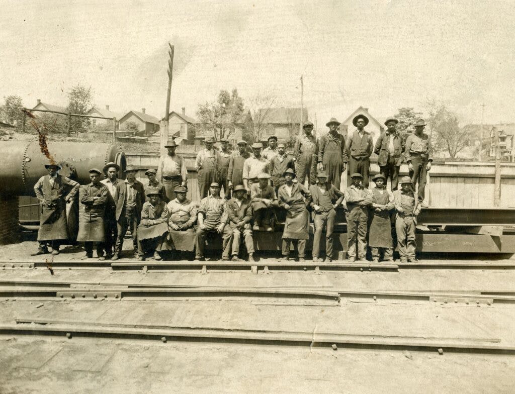 Old photo of african american workers standing on railroad tracks