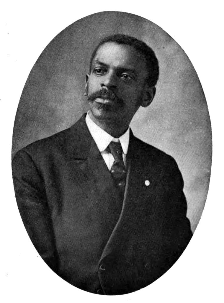 Black and white portrait of A.J. Oliver in a suit