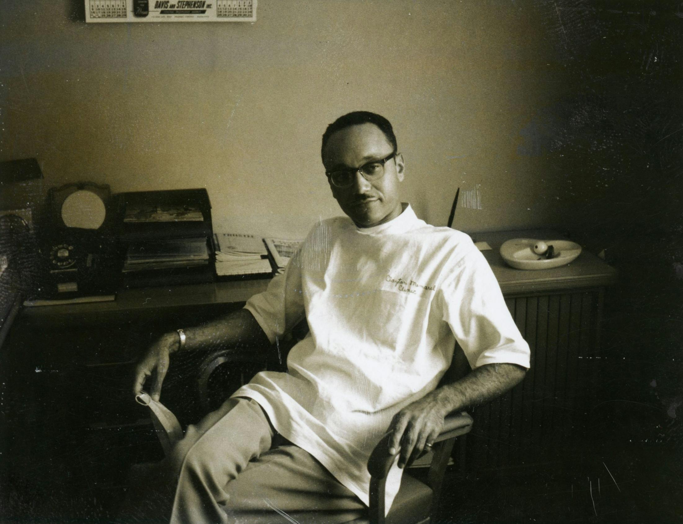 Dr. Claytor sitting happily in a chair at a desk